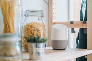 Smart speaker and two jars of pasta on a wood shelf