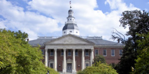 state capitol of Maryland, a large 18th century brick building with columns with its dome against a blue sky