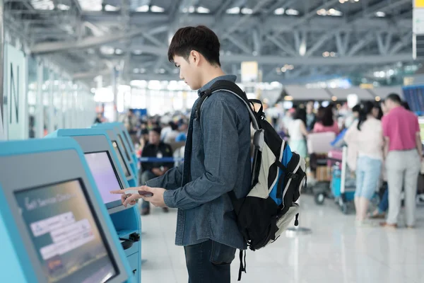 A man uses an airport kiosk