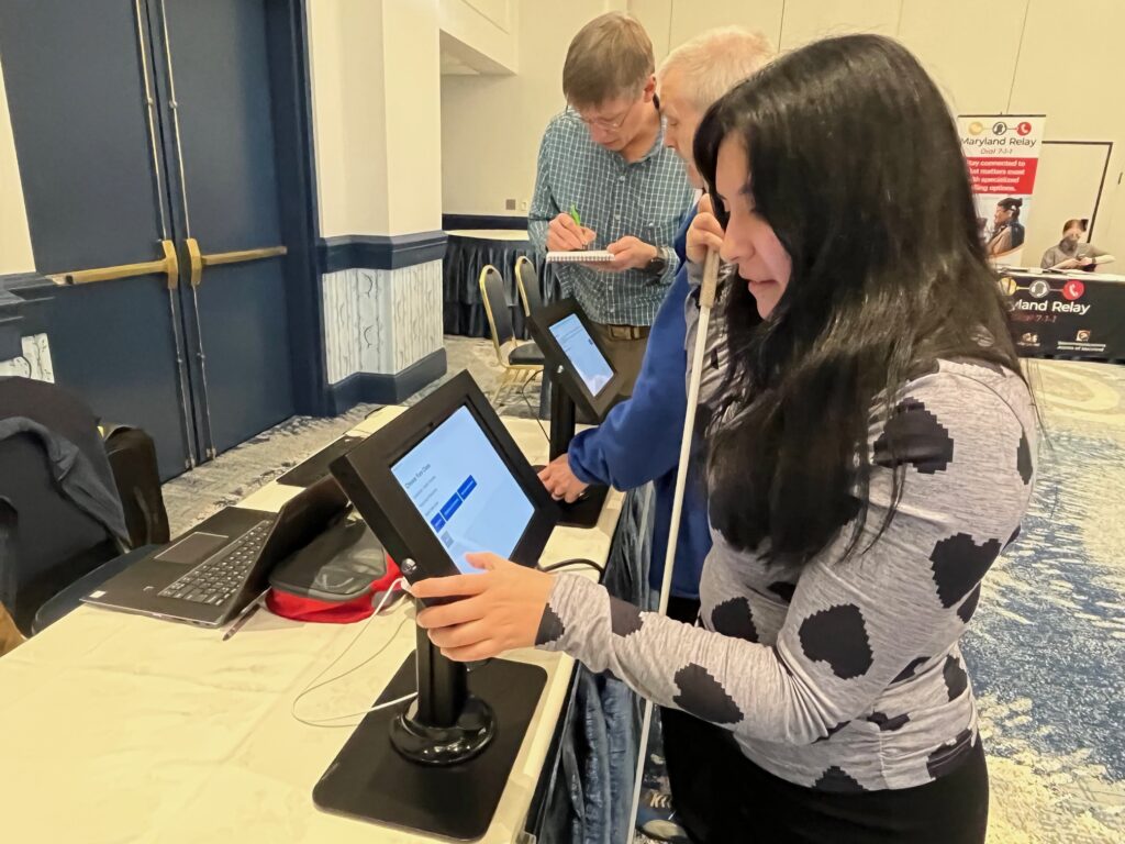 a girl with a cane uses a kiosk